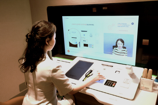 부평 고객센터를 방문한 고객이 화상상담창구 '디지털 데스크'를 이용해 금융 업무를 보고 있다. <한화생명 제공>